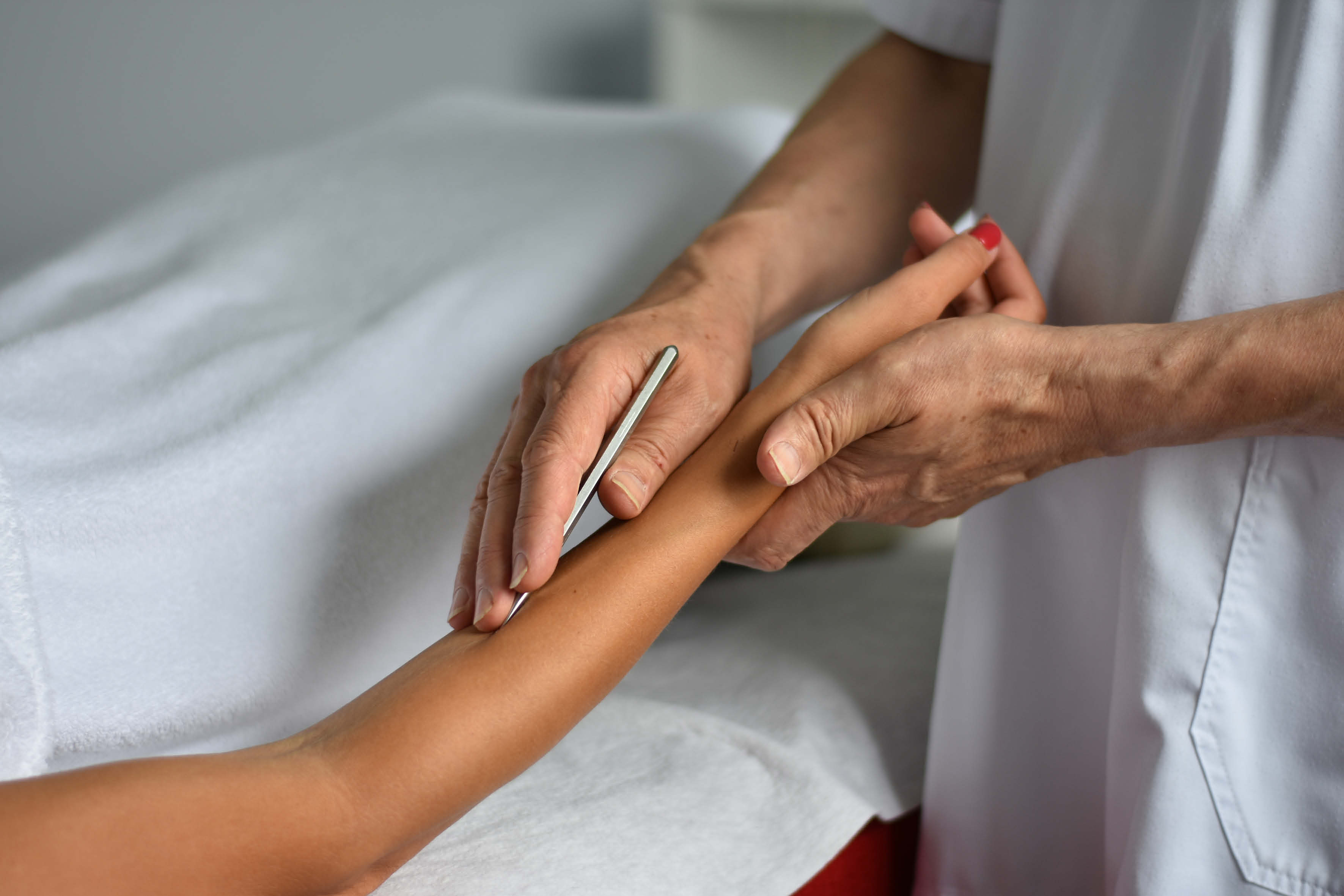 Therapeut behandelt den Unterarm einer Patientin im Rahmen der Therapie der Mitte nach Wolfgang Geiger – Pranameda-Schule Bad Boll